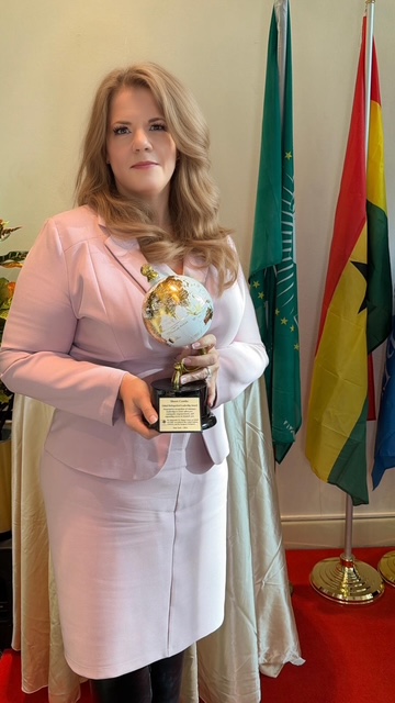 Sherri Combs holding the Global Distinguished Leadership Award, COJEP International, New York 2026.