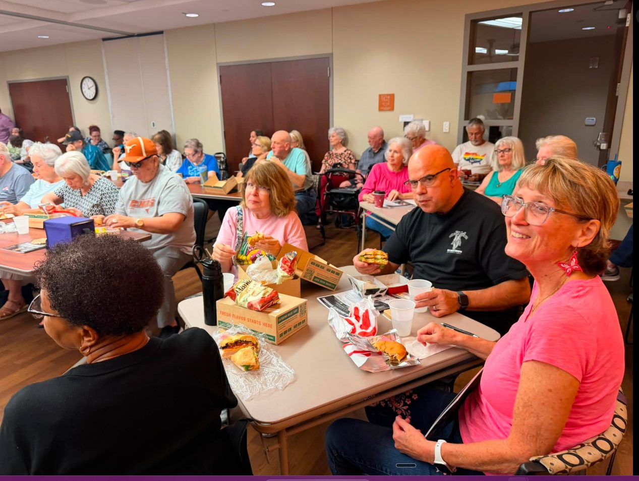 Seniors smiling during a community fraud-prevention workshop.